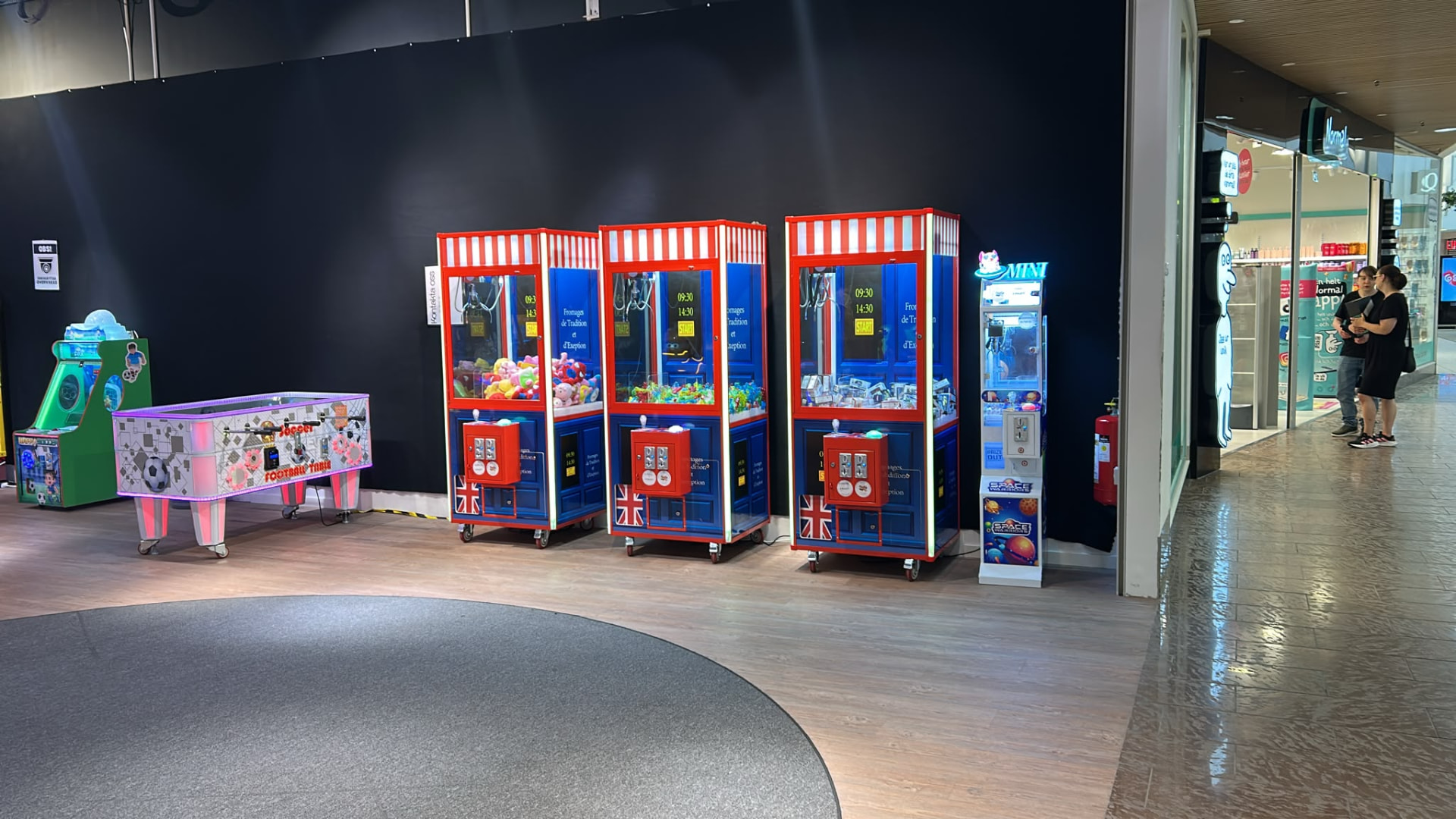 Klomaskiner, fotbollsspel och barnåk uppställda i en galleriagång i ett köpcentrum